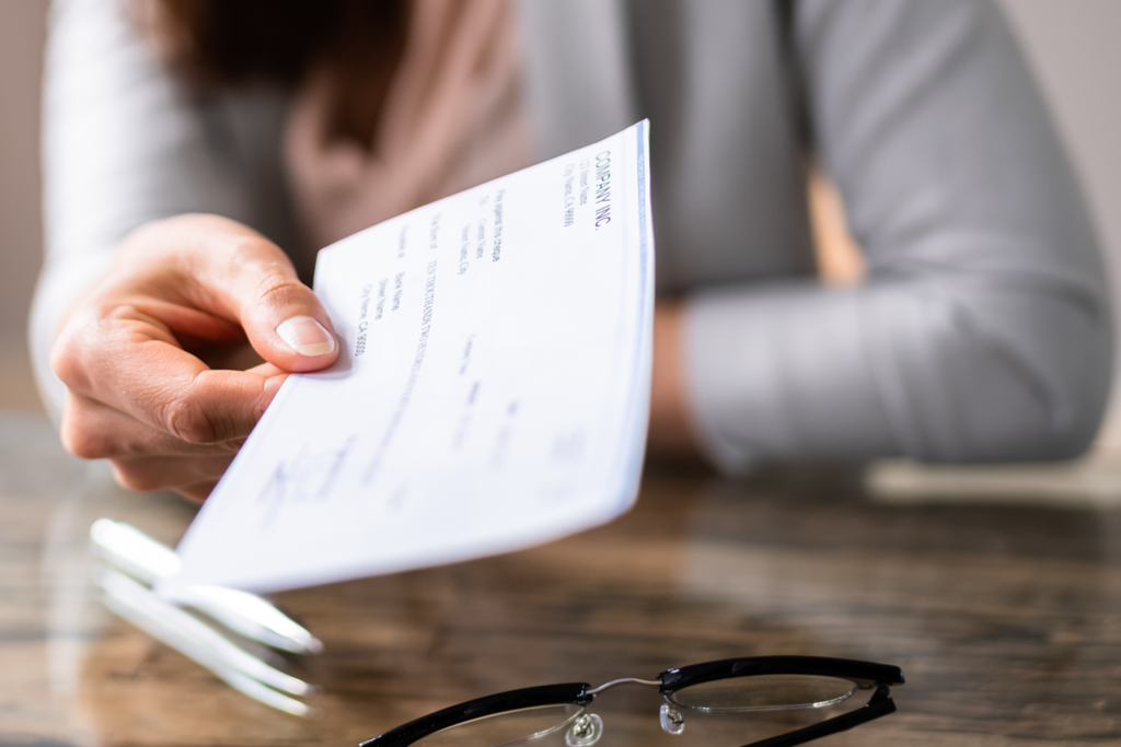 woman handing over business check