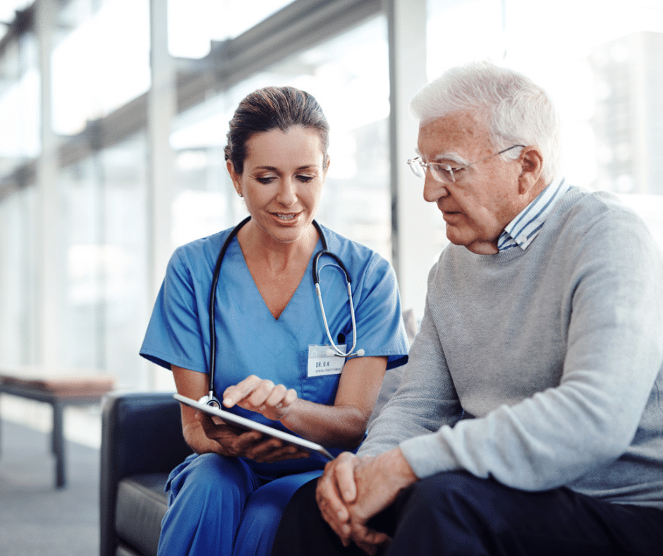 Health care worker shows senior man how to use an iPad for healthcare management.