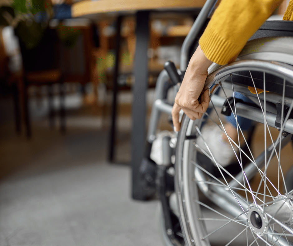 person in wheelchair pulling up to accessible table due to universal design