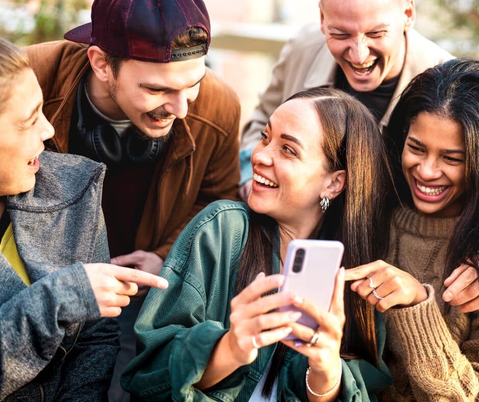 gen z redefining multifamily A group of Gen Z adults interacting with each other and their smart phones