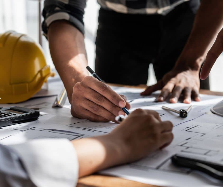 two construction pros review blueprint, illustrating design-build efficiencies