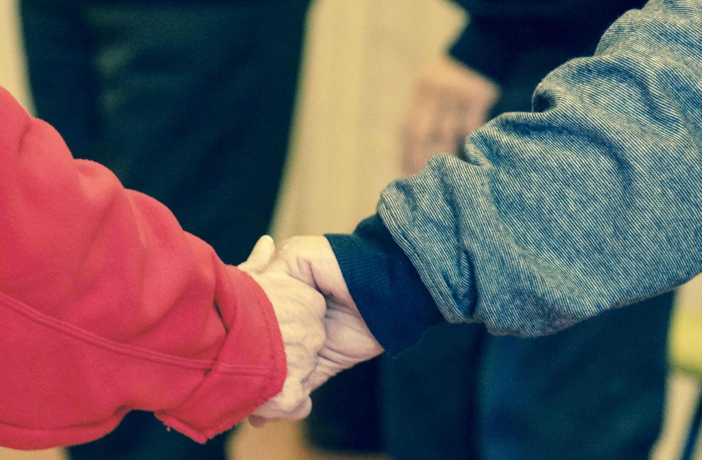 elderly couple holding hands