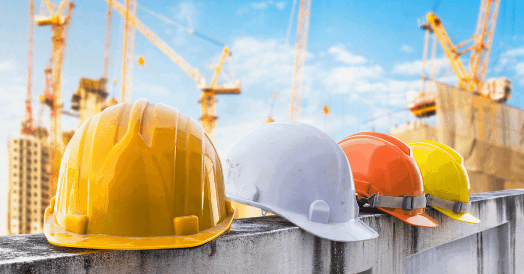Hard hats with construction cranes in background illustrate current procurement and labor pool situation.