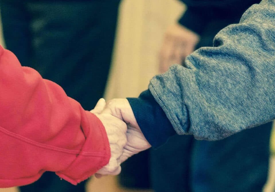 elderly couple holding hands