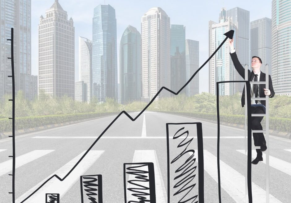 man draws line going up with city backdrop depicting uptick in financing requests