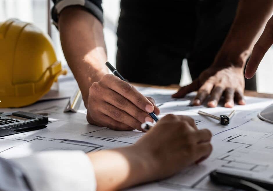 two construction pros review blueprint, illustrating design-build efficiencies