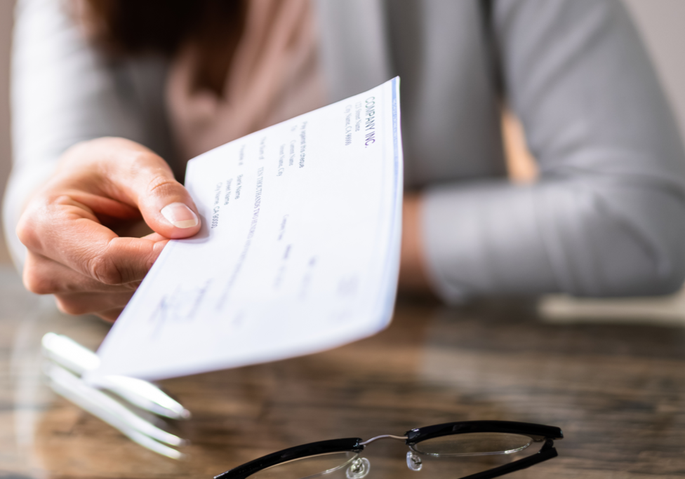 woman handing over business check