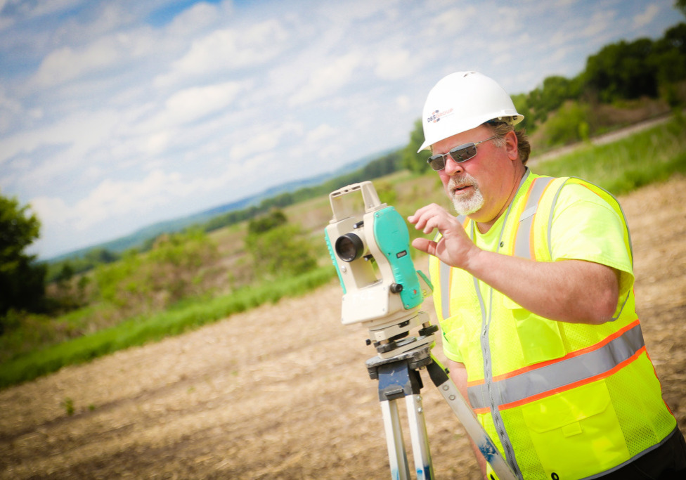construction worker surveying vacant land